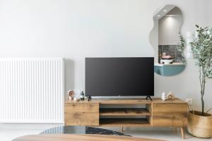 a living room with a flat screen tv on a wooden entertainment center at Manda Ray Seafront Apartment Endless Blue View in Perea