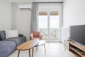 a living room with a couch and a table at Manda Ray Seafront Apartment Endless Blue View in Perea