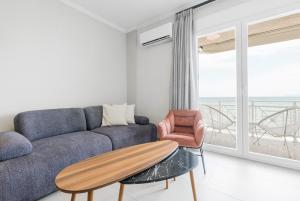 a living room with a couch and a table at Manda Ray Seafront Apartment Endless Blue View in Perea