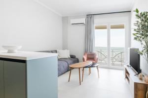 a living room with a couch and a table at Manda Ray Seafront Apartment Endless Blue View in Perea +14 photos