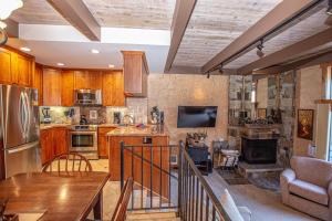 cocina con armarios de madera, mesa y fogones en Star Harbor # 27 By Hauserman Rentals, en Tahoe City