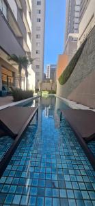 a swimming pool in a city with tall buildings at Studio Metrô Tatuapé Wi-fi-Piscina-Academia in Sao Paulo