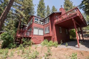 a red house with a deck in the woods at Highlands Lodge By Hauserman Rentals in Tahoe City
