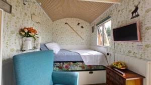 a small bedroom with a bed and a tv and a chair at Oor Hoose in Blairgowrie