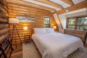 a bedroom with a large bed in a room with wooden walls at Little Bear Cabin By Hauserman Rentals in Tahoe Vista