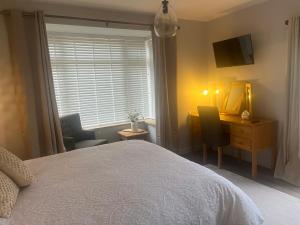 a bedroom with a bed and a desk and a mirror at Hillhouse in Felton
