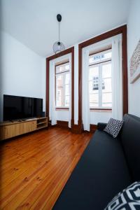 a living room with a couch and two windows at King's Guesthouse - Baixa de Coimbra in Coimbra