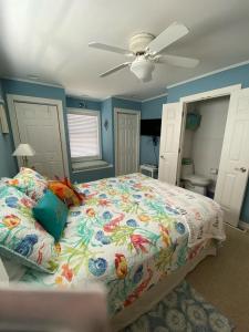 Un dormitorio con una cama y un ventilador de techo. en Welcome To Your Dream Vacation Rental In The Heart Of Peahala Park, Just Steps Away From The Pristine Beaches Of The Ocean Block, en Peahala Park