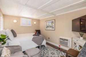 a bedroom with a white bed and a tv at Charming private guest house with pool in Tempe
