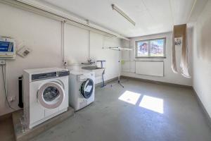 a laundry room with a washing machine and a washer at Classic Swiss Mountain Panorama in Kandersteg