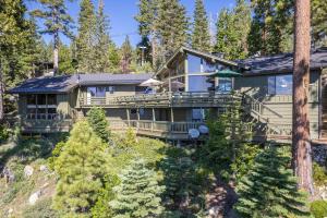 a large house in the woods with trees at McCown Lakefront By Hauserman Rentals in Tahoma