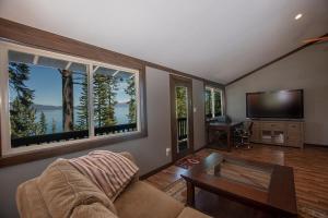 a living room with a couch and a tv and windows at McKinney Cove By Hauserman Rentals in Homewood