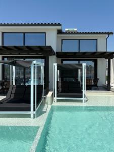 a house with glass doors and a swimming pool at Villa La Vida in Kallithea Halkidikis