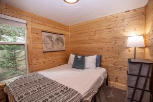 a bedroom with a bed in a wooden wall at O'Brien's Den By Hauserman Rentals in Tahoma