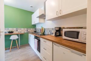 a kitchen with a counter top with a microwave at Le T2 Zen de Guingamp confort au coeur de la ville in Guingamp