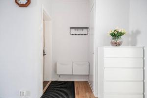 a hallway with a vase of flowers on top of a dresser at Artillerigatan in Landskrona