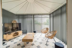 a living room with a flat screen tv and chairs at Appartement avec veranda et 3 chambres Guingamp in Guingamp