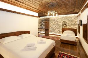 a bedroom with two beds and a chandelier at Oda e Gurit - Boutique Hotel in Berat +44 photos