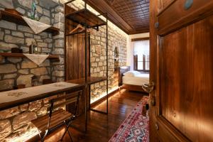 a room with a stone wall with a bedroom at Oda e Gurit - Boutique Hotel in Berat