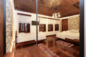 a bedroom with two beds and a tv in it at Oda e Gurit - Boutique Hotel in Berat