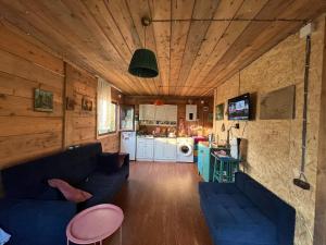 a living room with two blue couches and a kitchen at Welcome to Tamara Cottage in Tba