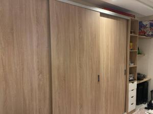 ein Schrank mit Holztüren in einem Zimmer in der Unterkunft magnifique famile appartement a harhoura in Temara
