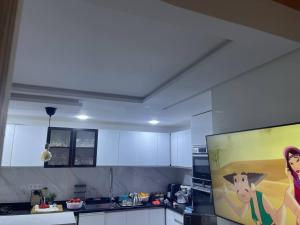 eine Küche mit einem Gemälde einer Frau und eines Hundes in der Unterkunft magnifique famile appartement a harhoura in Temara