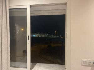 ein Fenster mit Blick auf eine Stadt in der Nacht in der Unterkunft magnifique famile appartement a harhoura in Temara