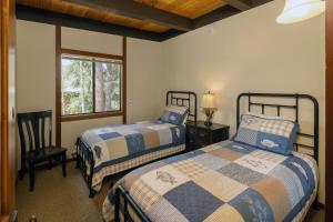 Un dormitorio con dos camas y una silla y una ventana. en Star Harbor # 4 By Hauserman Rentals, en Tahoe City 33 fotos más