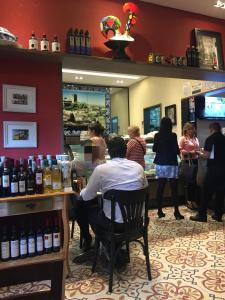 a group of people standing around a bar with wine bottles at Apartamento Cambui - Centro de Convivência in Campinas