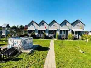 une rangée de maisons avec une aire de jeux dans la cour dans l'établissement Holiday Home in Mielenko near Seaside Beach, à Mielenko