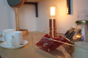 a table with a coffee cup and a glass container at The Tilman in Barmouth