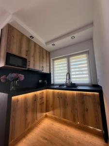 a kitchen with wooden cabinets and a sink at Zator Domki Dreampark in Zator