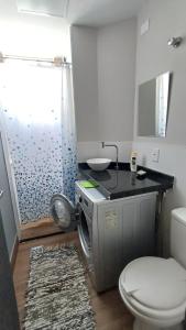 a bathroom with a washing machine and a toilet at Apartamento Cambui - Centro de Convivência in Campinas +9 photos