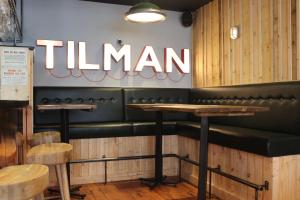 a restaurant with green seats and a sign that reads titan at The Tilman in Barmouth