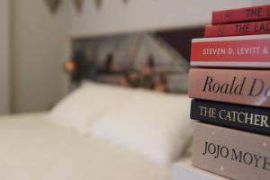 a stack of books sitting on top of a bed at The Tilman in Barmouth