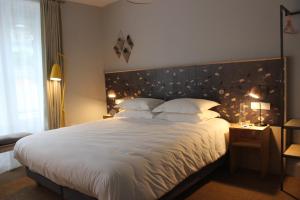 a bedroom with a large bed with white sheets and pillows at The Tilman in Barmouth