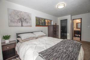 a bedroom with a large white bed and a dresser at Tahoma Treasures Emerald Cabin Hauserman Rentals in Tahoma
