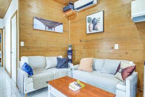 a living room with two couches and a table at 2 Mi to Family Attractions Brownsville Cottage! in Brownsville