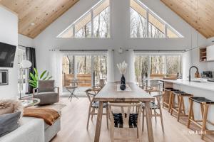 a kitchen and living room with a table and chairs at Aigle Blanc Comfort & Nature Spa Fireplace & Furnished Terrace in Pont-Rouge