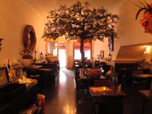 un ristorante con tavoli, sedie e un albero di Amadeus Hotel a Haarlem