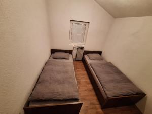 two beds in a small room with a window at Vikendica Ivan Blidinje in Blidinje