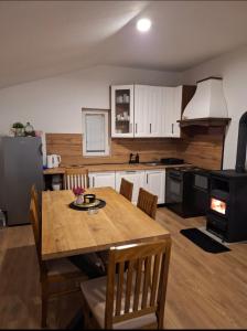 a kitchen with a wooden table and a dining room at Vikendica Ivan Blidinje in Blidinje