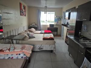 a small room with two beds in a kitchen at kitnet central com linda vista 75 in Ponta Grossa