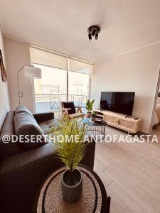 a living room with a couch and a tv at Departamento Centro Sur 1 Dormitorio 1 baño Full equipado in Antofagasta