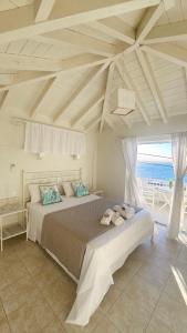 a bedroom with a bed with a view of the ocean at Ammos Boutique Rooms-Seafront Stay in Elafonisos in Elafonisos