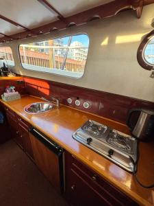 a kitchen with a sink and a counter with a window at Holländisches Stahlboot in Bremen