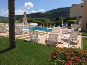 un groupe de chaises assises à côté d'une piscine dans l'établissement way2 stay Italy, à Pizzo