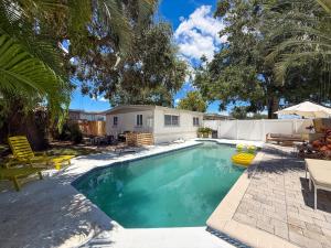 a swimming pool in a yard with a house at Modern 3BR Retreat with Pool & Fire Pit in Largo