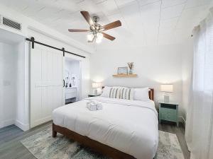a white bedroom with a bed and a ceiling fan at Modern 3BR Retreat with Pool & Fire Pit in Largo +42 photos